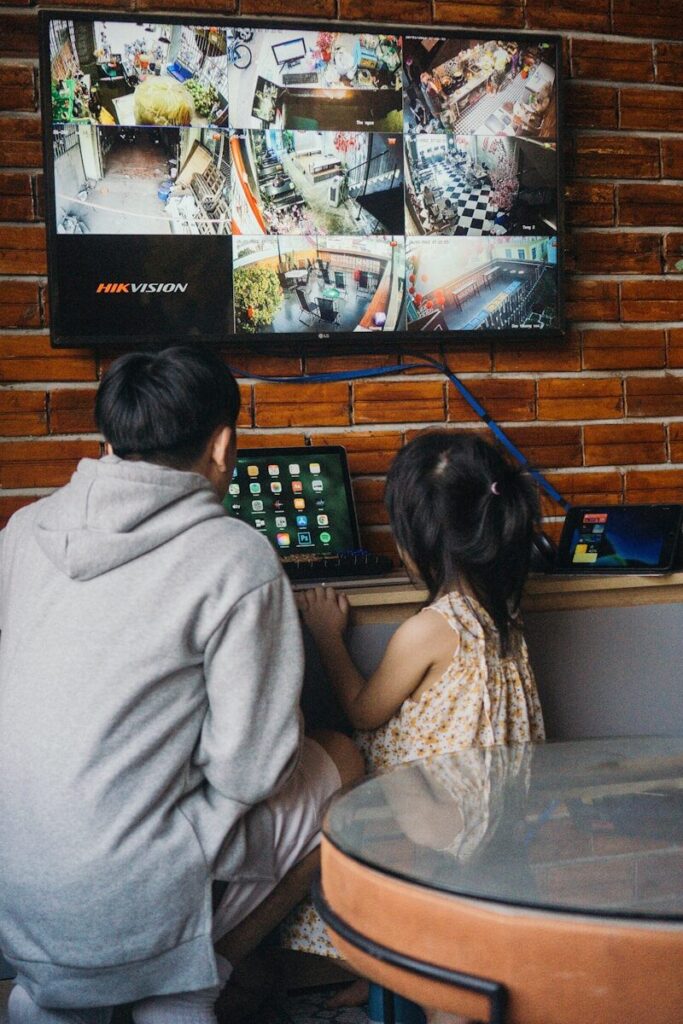 a woman and a child sitting at a table in front of a television